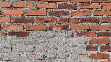 Abstract Defocused background photo of a red brick wall with a little spilled cement