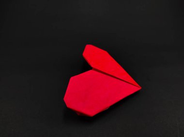 Soyut Odaklanmamış Turuncu Kalp şekilli origami siyah arkaplanda izole edildi