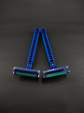 İki mavi jilet ve siyah arka planda izole edilmiş iki jilet.