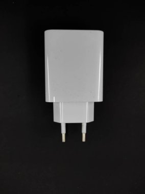 Siyah arkaplanda izole edilmiş beyaz akıllı telefon şarj cihazının soyut odaklanmış fotoğrafı