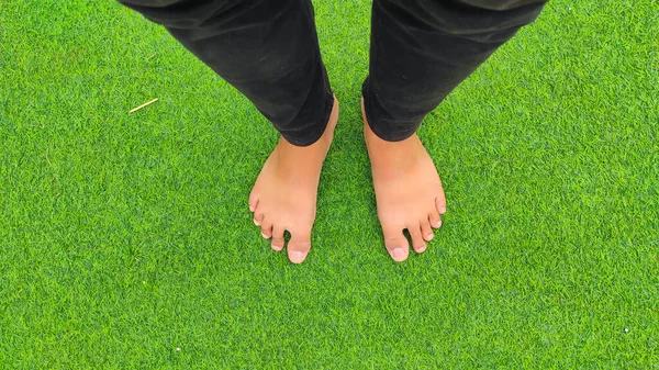 Absztrakt Defocused Feet Fekete Farmerben Egy Zöld Füves Szőnyegen Indonézia — Stock Fotó