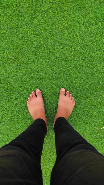 Absztrakt Defocused Feet Fekete Farmerben Egy Zöld Füves Szőnyegen Indonézia — Stock Fotó