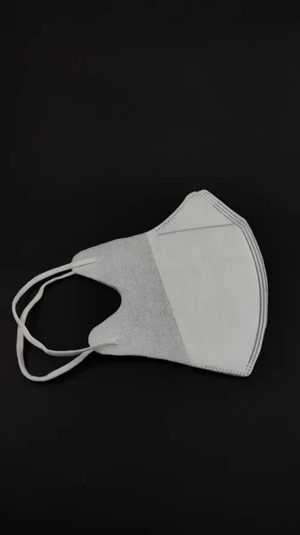 Foto Uma Máscara Branca Para Saúde Isolada Fundo Preto Não — Fotografia de Stock