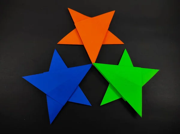 Abstraktní Rozostřená Tříbarevná Hvězda Papíru Origami Izolovaného Černém Pozadí — Stock fotografie