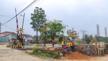 Cikancung, West Java, Endonezya - 28 Nisan 2022: Abstrakt Defocused inşaat işçileri demiryolu rayları yakınında toprak kazıyorlar, Endonezya