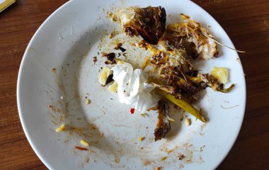 Pangandaran, Endonezya 'daki bir restoranda yemek artıklarıyla birlikte yuvarlak beyaz tabak.