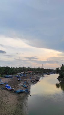 Endonezya 'nın Pangandaran bölgesinde nehir kıyısında balıkçı tekneleriyle dolu bir nehir.