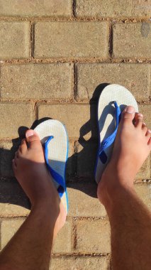 Abstract Defocused Background A pair of feet stepping on white and blue sandals in the afternoon in the Cikancung area - Indonesia. Not Focus