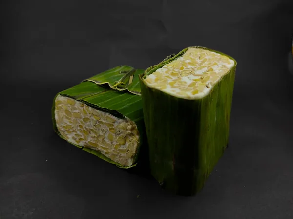 Photo Two Blocks Raw Tempeh Wrapped Banana Leaves Isolated Black —  Fotos de Stock