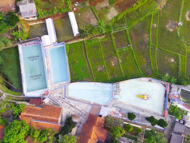 Endonezya 'nın Cikancung bölgesindeki pirinç tarlasının kenarındaki bir yüzme havuzunun bulanık arkaplan fotoğrafı. Odaklanma