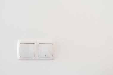 Beyaz fotokopi duvarındaki plastik çerçeveli çift ışık düğmesi. Oturma odası, ofis veya yatak odasında elektrikli ve modern ev aletleri kavramı