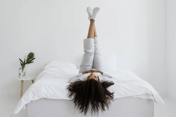 Gelukkig Zorgeloos Afrikaans Amerikaanse Vrouw Liggend Bed Een Pyjama Opgeheven — Stockfoto