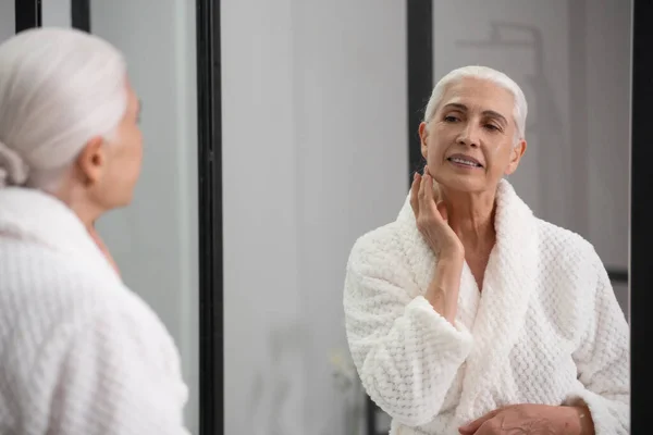 Çekici Yaşlı Kadının Portresi Aynaya Bakıyor Taze Nemli Yüzüne Dokunuyor — Stok fotoğraf
