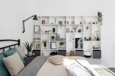 Modern mobilyalar ve ev dekorasyonu ile şık yatak odası iç tasarımının yan görünüşü. Lüks ve beyaz tonlarda rahat bir daire. Yerleşim alanı