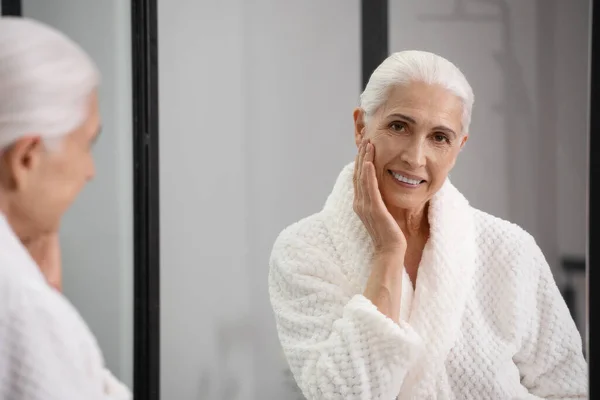 Portrait Pretty Smiling Aged Woman Looking Mirror Touching Her Glowing — Stock Photo, Image