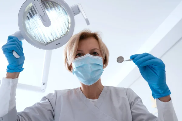 Low Angle View Professional Dentist Wearing Protective Face Mask Adjusts — 图库照片