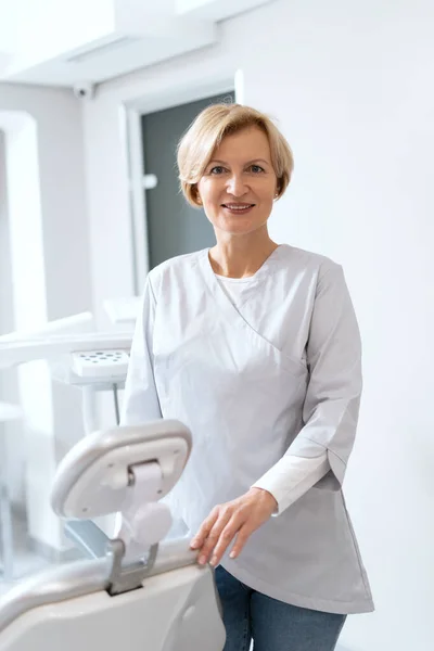 Porträtt Vacker Tandläkare Står Nära Stol Rymliga Skåp Sjukvårdskoncept Stomatologisektorn — Stockfoto