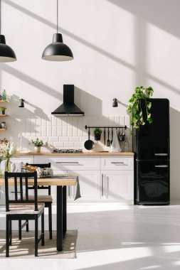 Minimalist tasarım, ahşap mobilyalar, dekorasyonlar ve ev aletleriyle modern mutfak tasarımı. Lamba konsepti olan parlak bir yemek odası. Lüks daire projesi