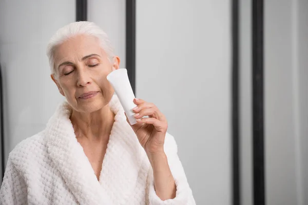 Portrait Elderly Woman Robe Holding Tube Cream Face Bathroom Pretection — Fotografia de Stock