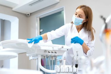 Modern diş malzemelerini silen dişçi asistanının yan görüntüsü. Çağdaş stomatoloji klinik servisi. Ağız sağlığı sektörü. Güvenlik ve sağlık standartlarına uyma
