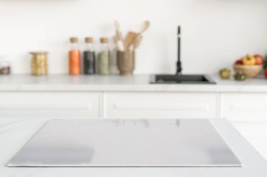 Kuzey mutfağındaki modern indüksiyon fırınına yakın çekim. Arka planda mutfak eşyaları ve dekor var. Tadilat üstüne tadilat. Modern cihazlar ve ev aletleri, seçici odak