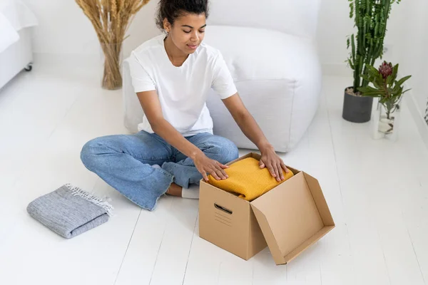 High View Afro American Teenager Folds Clothes Box Minimalism Lifestyle — Stock Photo, Image
