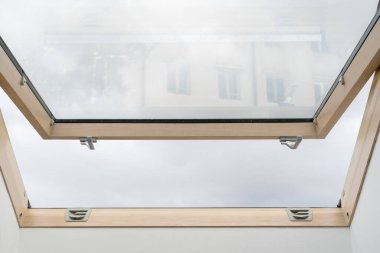 Modern odada çatı altında havalandırma için çift camlı mansard penceresi açık. Tavan penceresi, yenileme dairesi ve inşaat endüstrisi olan enerji tasarruflu ev reklamı.