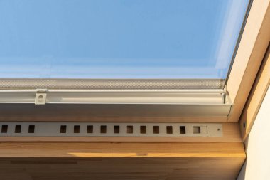 Ahşap çerçeve içerisindeki enerji tasarruflu tavan arası penceresini alüminyum profil ve silindir panjurlarla kapatın. Modern evde yenileme konsepti, güvenlik ve konfor