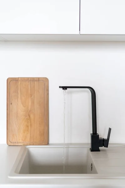 Černý Dřez Tekoucí Vodou Dřevěnou Řezací Deskou Skandinávského Kuchyňského Interiéru — Stock fotografie