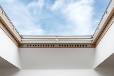 İnşaat endüstrisi konsepti. Ahşap çerçeveli yeni çift camlı mansard penceresinin geniş açık planı çatıda, çağdaş iç tasarımı olan modern dairede, beyaz fotokopi duvarının yanında