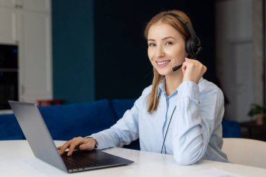 Laptop ve kulaklık kullanan ve evden çağrı merkezi operatörü olarak çalışan çekici bir kadının portresi. Uzaktan kumanda. Müşteri destek servisi. Müşterinin problem çözümü