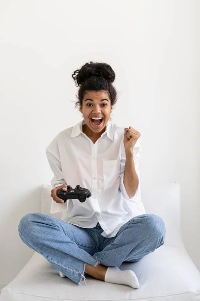 正面的非洲裔美国女士拿着操纵杆的肖像 并庆祝在视频游戏中获胜 青少年的业余爱好 视频游戏成瘾 青少年的娱乐时间 — 图库照片