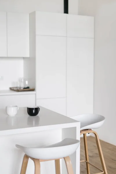 Seitenansicht Der Modernen Kücheneinrichtung Mit Barstühlen Tassen Auf Dem Tisch — Stockfoto