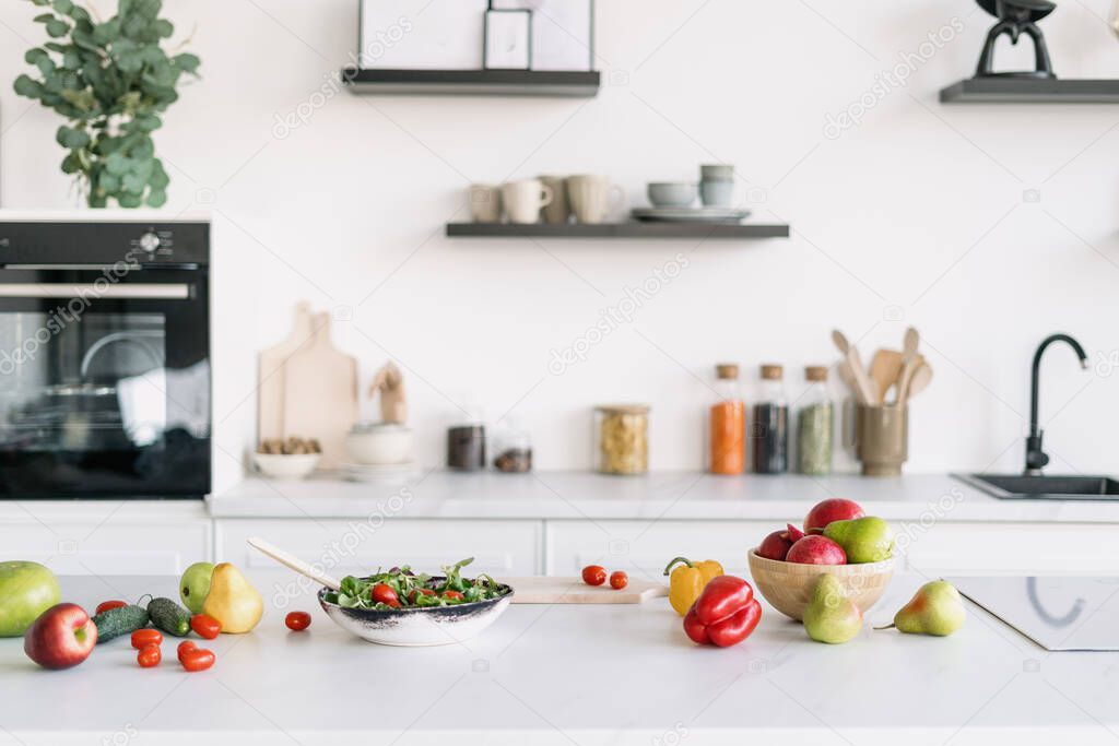 Bright and spacious kitchen interior design. Salad making. Cooking time. Kitchenware and decor on background. Clean cookware. Healthy food concept