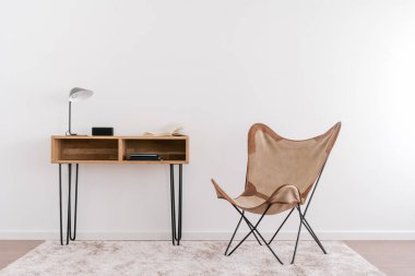 Lamba, açık kitap ve müzik sütunu tahta masanın yanında duruyor. Çağdaş oda iç tasarımı. Merkez ofis. Bağımsızlar için modern işyeri