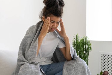 Baş ağrısından muzdarip üzgün ve yorgun Afrikalı Amerikalı bir kızın portresi. Kendimi kötü hissediyorum. Acı dolu bir yüz ifadesi. Sağlık sorunları. Tıp konsepti