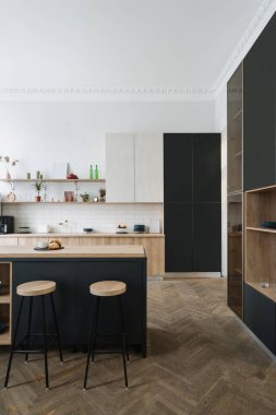 Ahşap mutfak dolabının dikey görüntüsü, depo dolabı, modern evdeki dekorlu raflar, mutfak aletleri ve mutfak malzemeleri. Mobilyalı yemek odası ve İskandinav iç tasarımı olan bir daire.