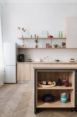 Lüks mobilyaları, yeni tezgahı ve ahşap dolabına karşı mutfak masası olan modern iç mekan. Ev aletleri, ev aletleri konsepti. Mobilyalı çatı katı tarzı bir daire.