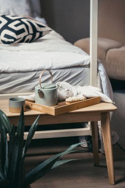 Sabahı yatakta geçirme kavramı, hafta sonu evde dinlenme. Krem şantili tatlı ekini, fincanda sıcak kahveyi ve bambu kahvaltı tepsisinde çaydanlığı yakından izle. Yemek ve içecekler yatak odasında.