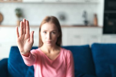 Sosyal reklam kavramı. Kameraya dur işareti yapan kadına odaklan. Aile içi şiddet ve istismarı protesto eden, zorbalık yapan, cinsiyet ayrımcılığına hayır diyen genç ve güçlü bir kadın.