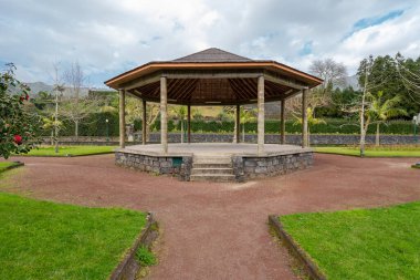 Yapı konsepti. Tahta çatının altında beton zemin olan geniş bir ahşap çardak planı. Şehir parkında yağmurdan korunmak için. Parkta boş bir arbour. İnsansız açık bir pavyon