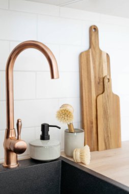 Mutfaktaki lavabonun yanındaki tahta kesme tahtası ve fırçalar. Bulaşıkları yıkıyorum. Ev konforu. Çevre dostu mutfak eşyaları. Ev aletleri
