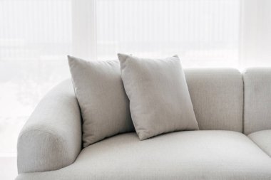 Modern oturma odası olan parlak dairedeki rahat gri kanepenin bir parçası. Yatak odasındaki döşekler ve kanepe fotokopi alanının arka planına karşı. Ev ve otel için zarif mobilya tasarımı kavramı