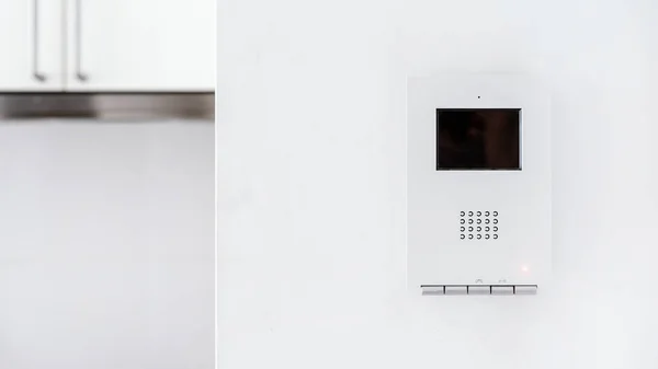 Smart home technology concept. Close up view of communication and video monitoring system with intelligence screen on wall installing at modern apartment