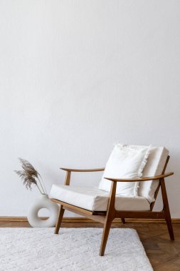 Beyaz antika koltuklu hafif bir daire ve fotokopi duvarına karşı vazoda kuru bitki olan ev dekorasyonu. Geçmişe dönük şezlonglu minimalist oturma odası, ahşap zeminde halı ve zarif ev dekorasyonu.