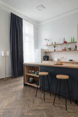 Yeni mutfak mobilyaları, dolapları ve bar sandalyeli yemek masasına yakın olan modern evin dikey görüntüsü. Yenileme konsepti ve modern iç mimari