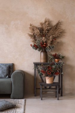 Vazolardaki kurumuş dalları, oturma odasının iç tasarımı olarak modern bir dekor olarak görüyordu. Ev konforu. Daire detayları. Süslemeli düz