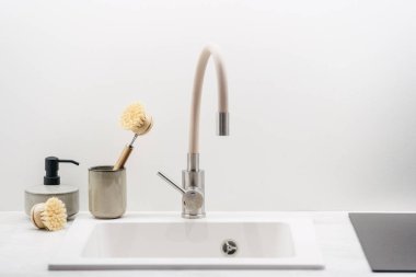 Mutfaktaki lavabonun yanında bulaşık yıkayan ahşap fırçalar. Ev konforu. Çevre dostu mutfak eşyaları. Sıfır atık ev ekipmanı