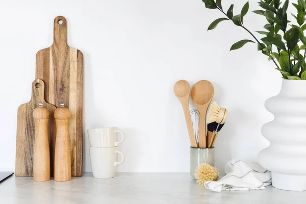 Closeup of eco-friendly kitchenware on ceramic surface. Home comfort and decor. Organizational space in kitchen. Set of crockery. Bamboo equipment for kitchen