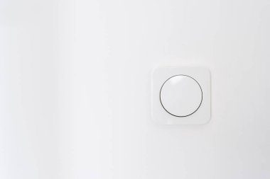 Cropped view of white light switch on wall in modern living room. Apartment after renovation. Energy saving. Safety and comfort concept. House interior design details